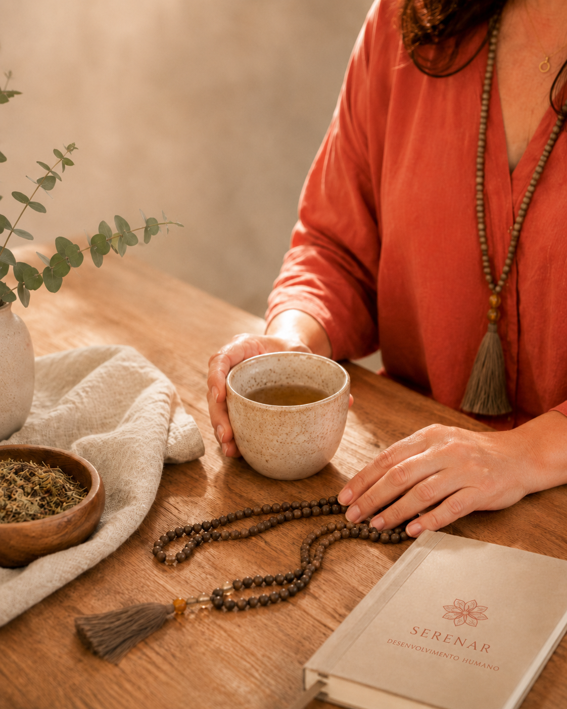 Caderno Serenar, chá e japamala sobre a mesa de madeira